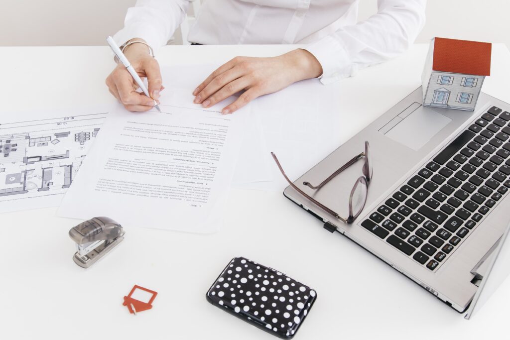 overhead-view-human-hand-putting-signature-official-paper-office-1-min